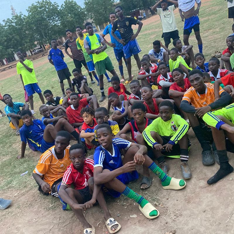 A large group of young players resting on the grass after training