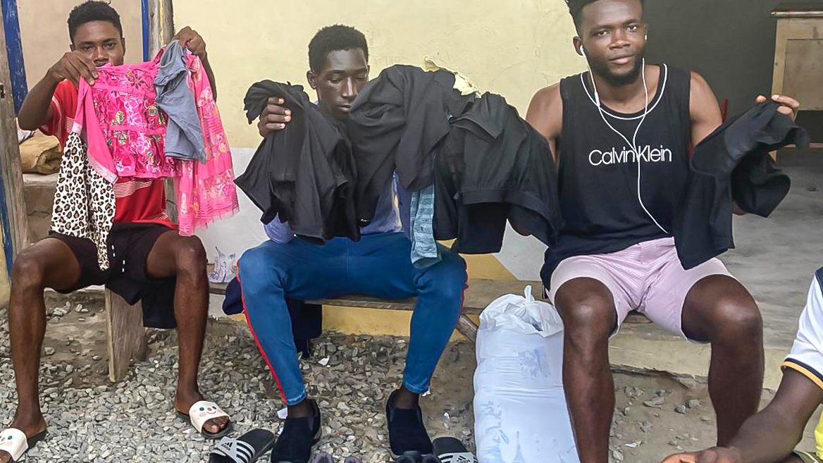 Young men sorting through donated clothing and footwear