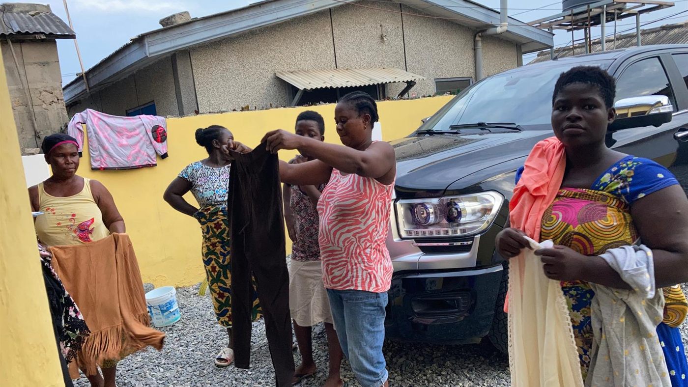 Women selecting from donated clothing at a community distribution in Ghana